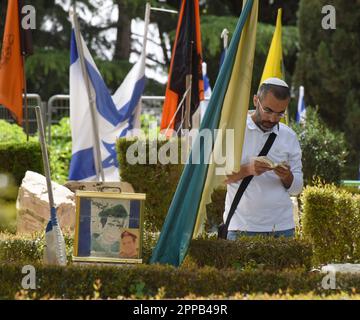 Jerusalem, Israel. 02. Februar 2014. Ein Israeli betet am Grab eines gefallenen Soldaten am Mt. Herzl Militärfriedhof in Jerusalem am Sonntag, den 23. April 2023. Israel wird am 24. April den Gedenktag für Soldaten und Terroropfer bei Sonnenuntergang begehen. Foto von Debbie Hill/ Kredit: UPI/Alamy Live News Stockfoto