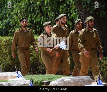 Jerusalem, Israel. 02. Februar 2014. Israelische Soldaten bereiten sich darauf vor, Nationalflaggen mit schwarzen Bändern auf die Gräber gefallener Soldaten am Mt. Herzl Militärfriedhof in Jerusalem am Sonntag, den 23. April 2023. Israel wird am 24. April den Gedenktag für Soldaten und Terroropfer bei Sonnenuntergang begehen. Foto von Debbie Hill/ Kredit: UPI/Alamy Live News Stockfoto