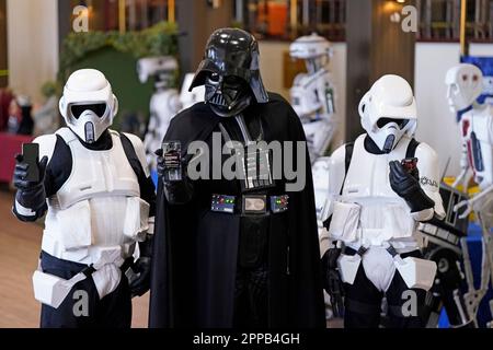 Ein Cosplayer verkleidet als Darth Vader und Cosplayers verkleidet als Stormtroopers mit ihren Handys während eines Tests eines neuen öffentlichen Notfallwarnsystems während des Sci Fi Scarborough im Spa-Komplex in Scarborough. Foto: Sonntag, 23. April 2023. Stockfoto