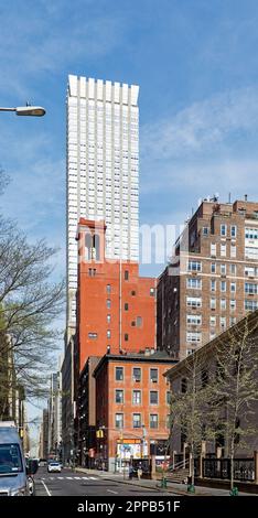 Die dunkelrote Backsteinfassade von Morgan Lofts und die hohen Kolonnaden bilden einen scharfen Kontrast zum Himmel und dem Langham an der 36. Street im Murray Hill in Manhattan. Stockfoto