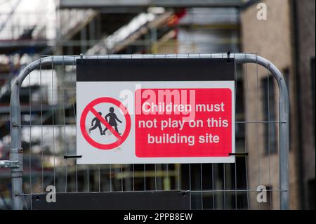 Kinder halten am Sicherheitsschild auf der Baustelle ein Schild aus Stockfoto