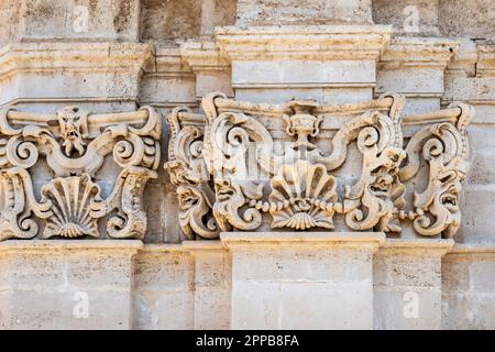 Groteske Masken schmücken das Äußere der achteckigen Basilika Santuario Santa Lucia al Sepolcro aus dem Jahr 17c in Siracusa, Sizilien, wo St. Lucia begraben ist Stockfoto