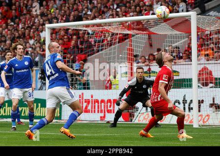 23. April 2023, Baden-Württemberg, Freiburg im Breisgau: Fußball: Bundesliga, SC Freiburg - FC Schalke 04, Matchday 29, Europa-Park Stadion: Freiburgs Lucas Höler (r) schaut auf den Ball über ihm, daneben ist Schalke's Henning Matriciani und hinter Höler Fotowärter Alexander Schalke Schwolow. Philipp von Ditfurth/dpa - WICHTIGER HINWEIS: Gemäß den Anforderungen der DFL Deutsche Fußball Liga und des DFB Deutscher Fußball-Bund ist es verboten, im Stadion aufgenommene Fotografien und/oder das Spiel in Form von Sequenzbildern und/oder videoähnlichen Bildern zu verwenden oder verwenden zu lassen Stockfoto