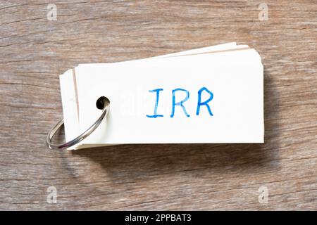 Flash card with handwriting in word IRR (Abbreviation of internal rate of return) on wood background Stockfoto