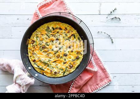 Hausgemachter Speck und Spargelfrittata auf einem Kühlregal, serviert. Stockfoto