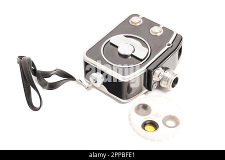 Oldtimer-Filmkamera mit auf Weiß isolierten Filtern. Stockfoto