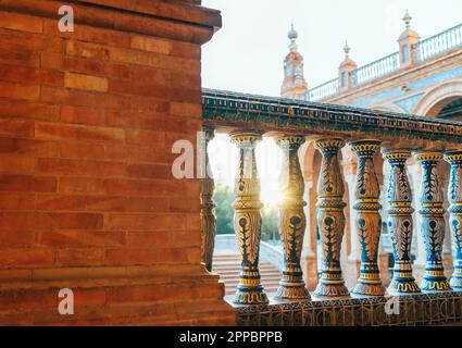 Die Galerien auf der Plaza de España erstrahlen abends in der Sonne. Blick auf den Spanien Square, Andalusien und Südspanien mit bemalten Balustern. Stockfoto