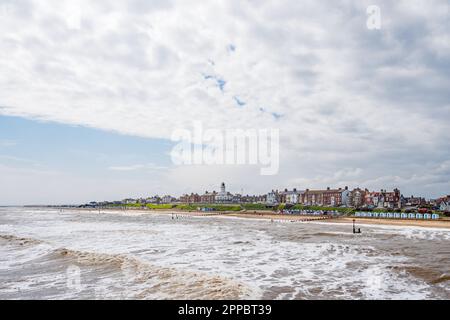 Vom Pier in Southwold aus in Richtung Strand, Leuchtturm und Stadt mit einer östlichen Brise, die das Meer aufschäumt, Stockfoto