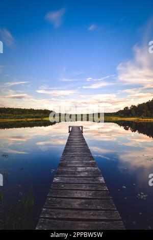 Wunderschöne Sommerlandschaft am Nachmittag am See. Charmanter Holzpier über einem kleinen See in Michala Gora, Polen. Stockfoto