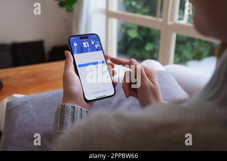 CHIANG MAI , THAILAND - 21. April 2023 : Woman Hand using iPhone 14 with facebook Application by Metaverse. Amerikanisches digitales Unternehmen, Eigentümer von Facebook Stockfoto