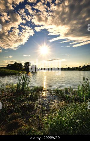 Wunderschöne, farbenfrohe Landschaft am See auf dem Land. Sonnenuntergang auf dem Mojcza-See in der Nähe von Kielce, Polen. Stockfoto