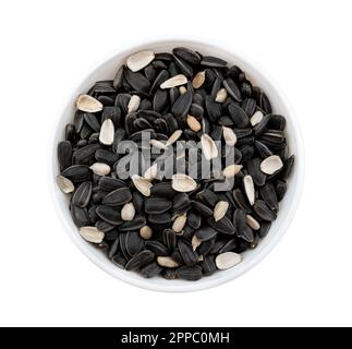 Sonnenblumenkerne, geschält und ungeschält, liegen in einer weißen Schüssel auf weißem Hintergrund. Draufsicht der Seeds Stockfoto