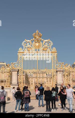 Das goldene Eingangstor des Schlosses von Versailles mit Touristen. Stockfoto