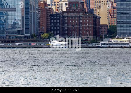 Tropic Oceans Airways Cessna 208B startet vom New York Skyports Seaplane Base am East River. Hintergrund: HRA Men’s Shelter Stockfoto