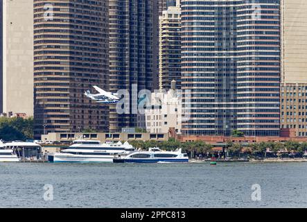 Tropic Oceans Airways Cessna 208B startet vom NY Skyports Seaplane Base. Hintergrund: Manhattan Place, die Corinthian und Horizon Wohnanlagen. Stockfoto