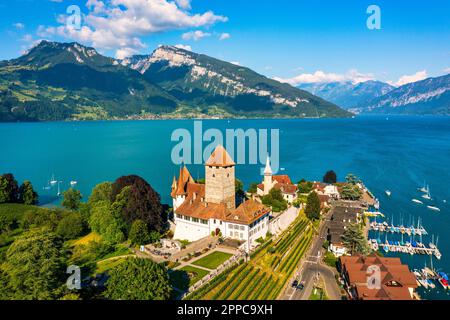 Panoramablick auf die Spiez-Kirche und das Schloss am Thunersee im Schweizer Kanton Bern bei Sonnenuntergang, Spiez, Schweiz. Schloss Spiez weiter Stockfoto