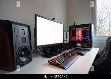 Maßgeschneiderter Gaming-Computer mit weißem Bildschirm, Tastatur, Maus, Desktop-PC, Komponenten, Hardware, Spielstuhl. Moderne PC-Gaming-Einrichtung auf dem Schreibtisch. Mod Stockfoto