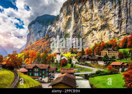 Faszinierender Herbstblick auf das Lauterbrunnen-Tal mit herrlichem Staubbach-Wasserfall und Schweizer Alpen bei Sonnenuntergang. Lauterbrunnen Dorf mit Herbstrot Stockfoto