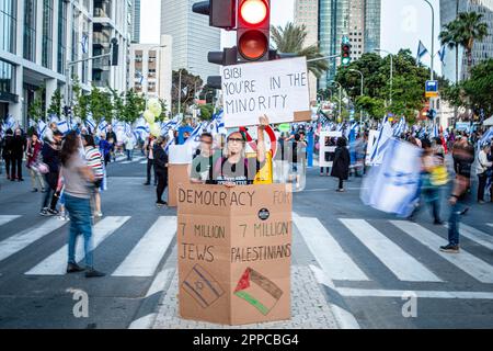 Tel Aviv, Israel. 22. April 2023. Während einer Anti-Reform-Demonstration in Tel Aviv hält ein Anti-Besatzungs-Protestteilnehmer Plakate. Hunderte von Menschen meldeten sich für die 16. Woche am Samstag gegen Netanjahus Pläne zur Generalüberholung der Gerichte der Koalition. Bei der Hauptproteste in Tel Aviv richteten Mitglieder von Hinterbliebenen ein provisorisches Denkmal mit Kerzen zum Gedenken an gefallene Soldaten ein. Die Familien drängten die Politiker, sich am Memorial Day, der Montag bei Einbruch der Dunkelheit beginnt und Dienstagabend mit dem Beginn des Unabhängigkeitstages endet, von den Friedhöfen fernzuhalten. Kredit: SOPA Images Limited/Alamy Live News Stockfoto