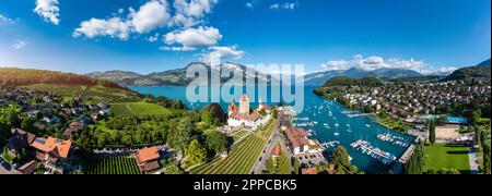 Panoramablick auf die Spiez-Kirche und das Schloss am Thunersee im Schweizer Kanton Bern bei Sonnenuntergang, Spiez, Schweiz. Schloss Spiez weiter Stockfoto