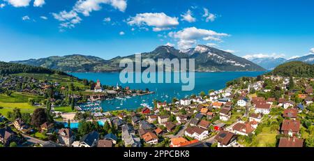Panoramablick auf die Spiez-Kirche und das Schloss am Thunersee im Schweizer Kanton Bern bei Sonnenuntergang, Spiez, Schweiz. Schloss Spiez weiter Stockfoto