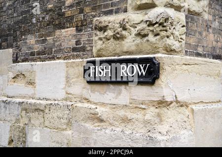 Fish Row Straßenschild an alter Steinmauer Stockfoto