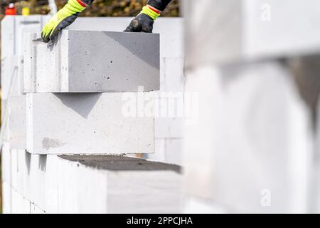 Ein Maurer baut die Mauer eines Hauses mit Ziegeln Stockfoto