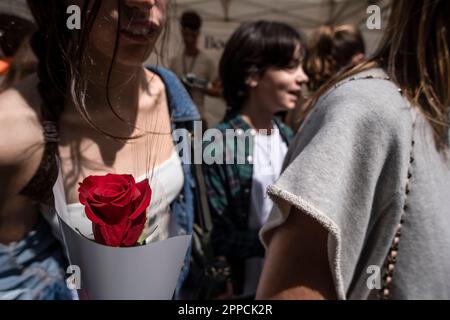 Barcelona, Spanien. 23. April 2023. Eine junge Frau trägt eine rote Rose in der Hand. Katalonien feiert am 23. April jährlich den Tag von Sant Jordi, das traditionelle Buch- und Rosenfest. Die Straßen sind voller Verkaufsstände, die Bücher und Rosen verkaufen. Kredit: SOPA Images Limited/Alamy Live News Stockfoto