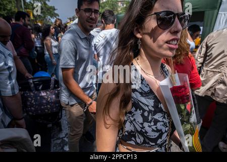 Barcelona, Spanien. 23. April 2023. Eine junge Frau trägt eine rote Rose in der Hand. Katalonien feiert am 23. April jährlich den Tag von Sant Jordi, das traditionelle Buch- und Rosenfest. Die Straßen sind voller Verkaufsstände, die Bücher und Rosen verkaufen. (Foto: Paco Freire/SOPA Images/Sipa USA) Guthaben: SIPA USA/Alamy Live News Stockfoto