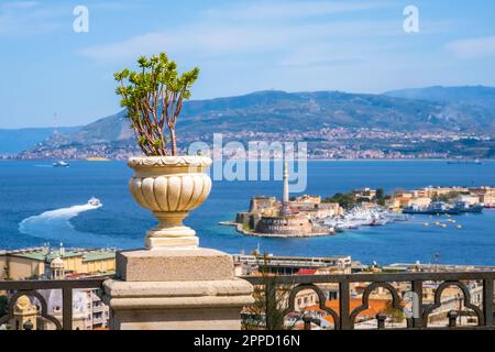 Italienischer Balkon mit Pflanze im Zementtopf. Boot in der Straße von Messina zwischen Sizilien und Italien. Messina, die Statue von Madonna della Lettera und Stockfoto