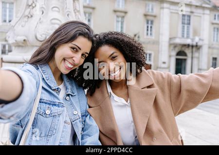 Glückliche Freunde machen Selfie vor dem Gebäude Stockfoto