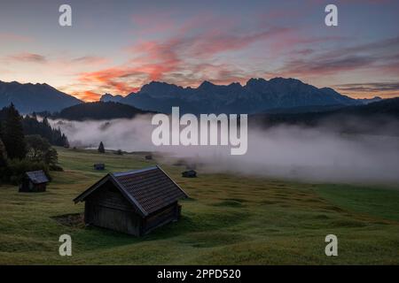 Deutschland, Bayern, dichter Morgennebel über dem Geroldsee mit Hütte im Vordergrund Stockfoto