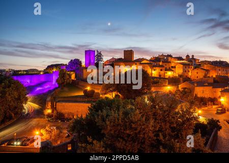 Italien, Latium, Toskanien, Blick auf den Torre di Lavello, der in der Abenddämmerung von violettem Licht beleuchtet wird Stockfoto