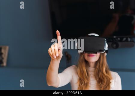 Frau mit Virtual-Reality-Headset, die zu Hause Gesten trägt Stockfoto