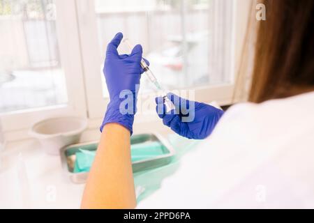 Hände des Arztes, der die Impfspritze im Krankenhaus vorbereitet Stockfoto