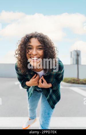 Glückliche junge Frau mit lockigem Haar Stockfoto
