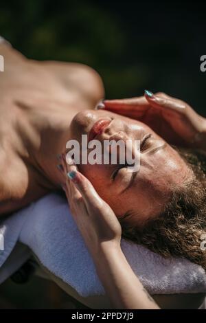 Frau bekommt Gesichtsmassage im Wellnesscenter Stockfoto