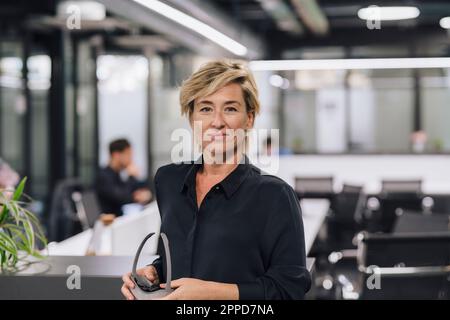 Reife Geschäftsfrau mit VR-Brille im Büro Stockfoto