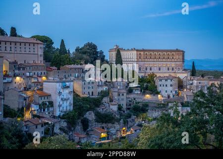 Italien, Latium, Caprarola, Altstadthäuser in der Abenddämmerung mit Villa Farnese im Hintergrund Stockfoto