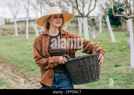 Lächelnder Bauer, der in einem Farmkorb herumläuft Stockfoto