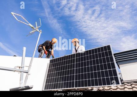 Ingenieure installieren Sonnenkollektoren an sonnigen Tagen Stockfoto