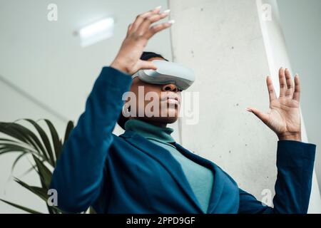 Geschäftsfrau, die ein Virtual-Reality-Headset trägt Stockfoto