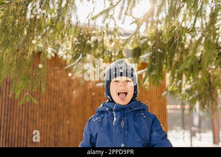 Ein Junge, der im Winter die Zunge rausstreckt Stockfoto