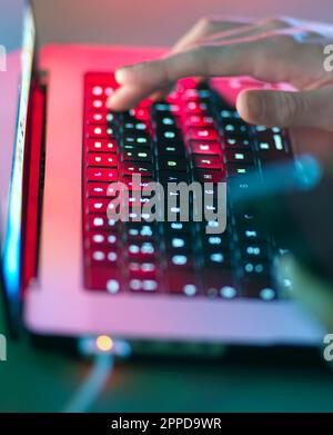 Mann, der im Büro auf einer beleuchteten Tastatur tippt Stockfoto