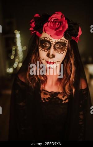 Eine Frau trägt das Day of the Dead-Kostüm mit Make-up-Gesicht Stockfoto