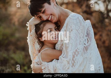 Glückliche Mutter umarmt süße Tochter Stockfoto