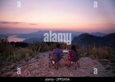Ein Paar isst bei Sonnenuntergang zusammen zu Abend Stockfoto