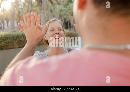 Lächelnde Frau, die einem Mann High Five gibt Stockfoto