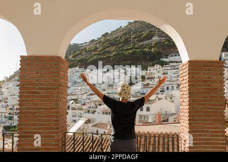 Ein Mann mit erhobenen Armen, der unter dem Bogen steht Stockfoto