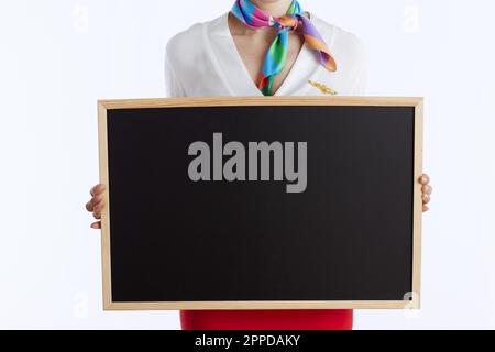 Nahaufnahme einer modernen weiblichen Stewardess isoliert auf weißem Hintergrund in Uniform mit leerem Brett. Stockfoto